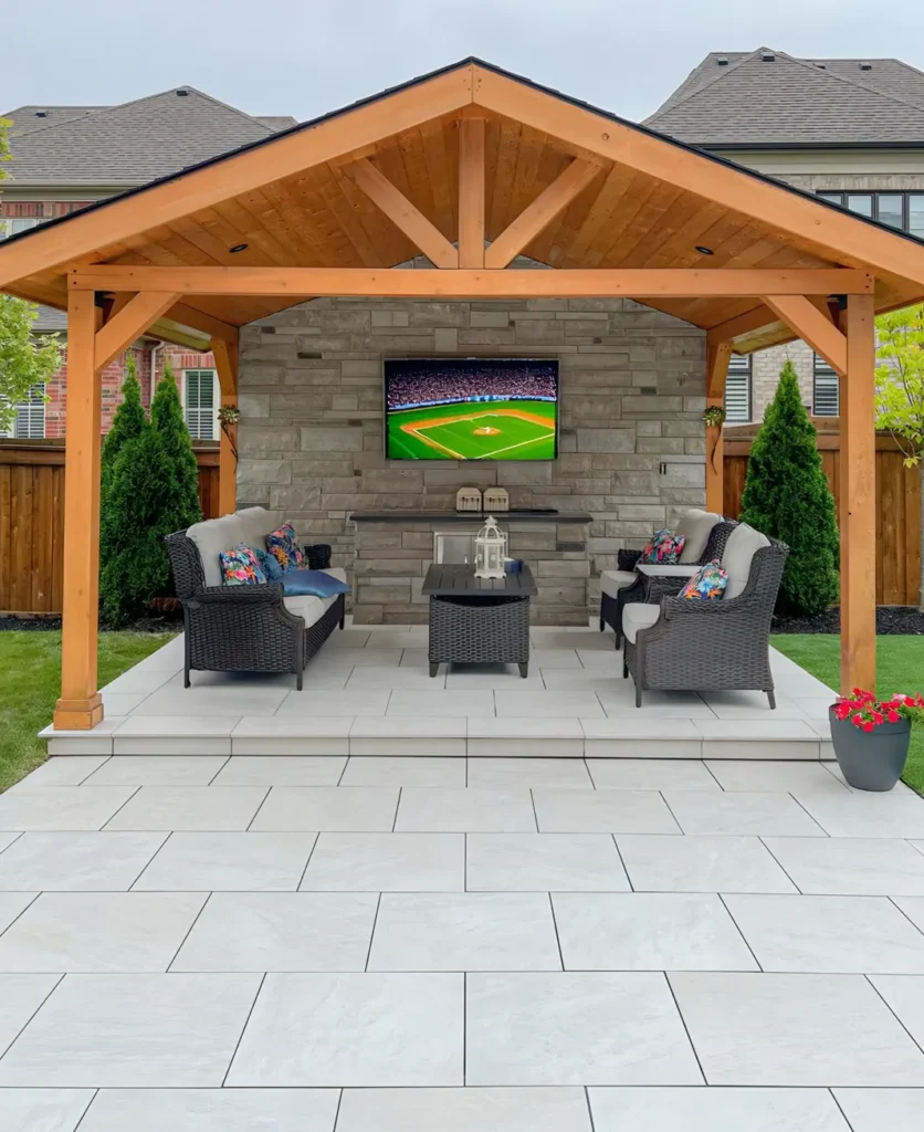 A backyard deck and structure with a TV in it installed by Mutti Landscaping