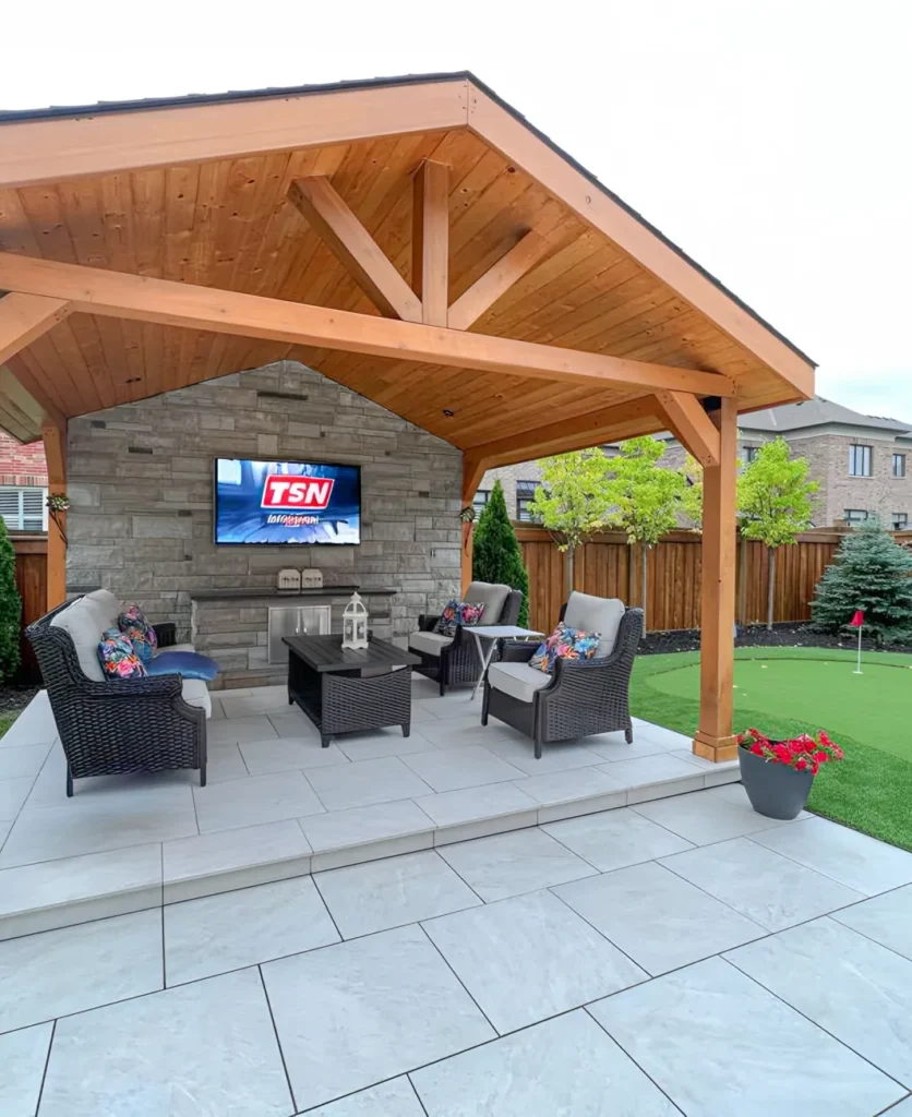 A backyard deck and structure with a TV in it installed by Mutti Landscaping