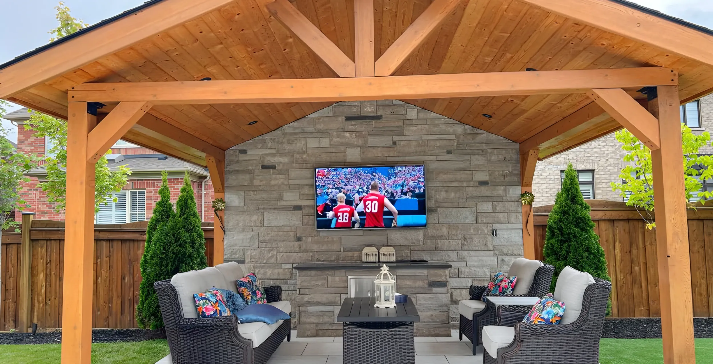 A backyard deck and structure with a TV in it installed by Mutti Landscaping