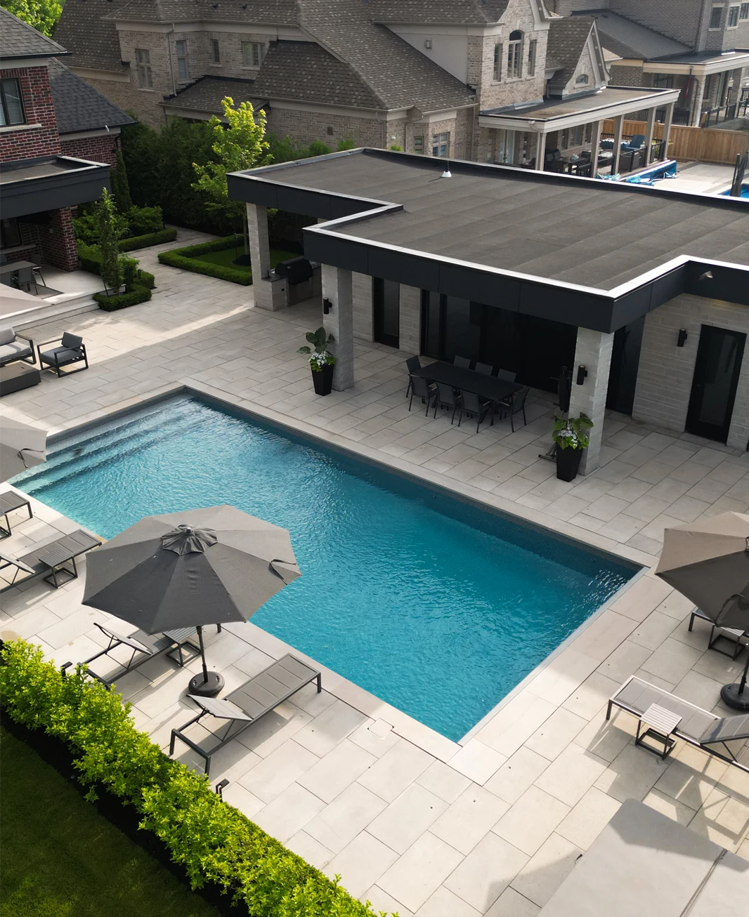 Aerial view of a gorgeous pool coping, flag stone and natural stone installation project completed by Mutti Landscaping