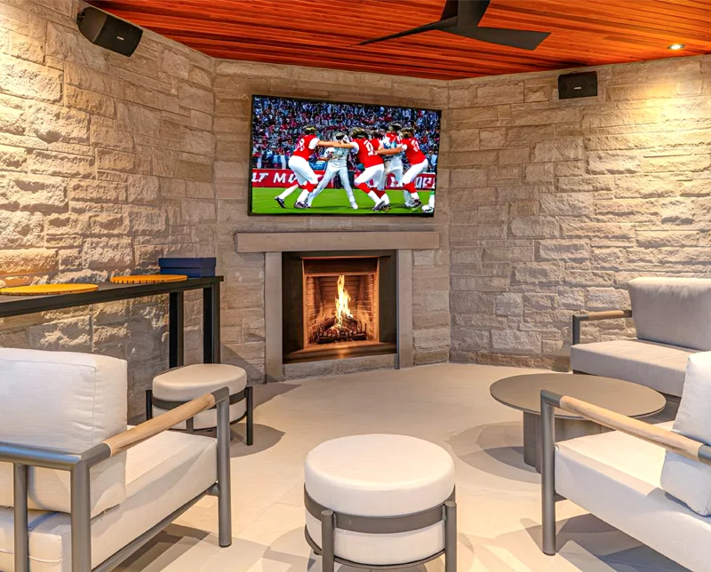 An outdoor cabana lounge area with TV installed by Mutti Landscaping