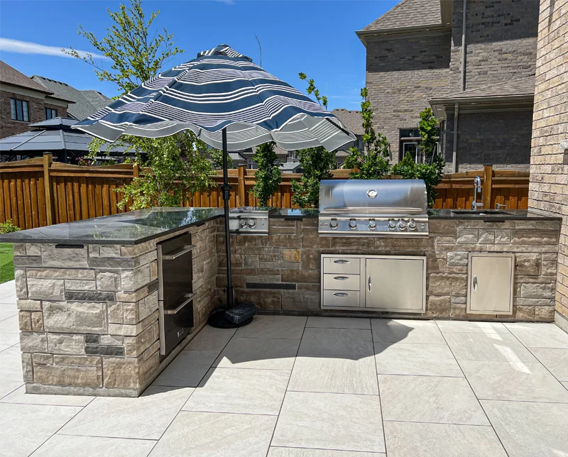 An outdoor kitchen installed in the backyard of a home by Mutti Landscaping